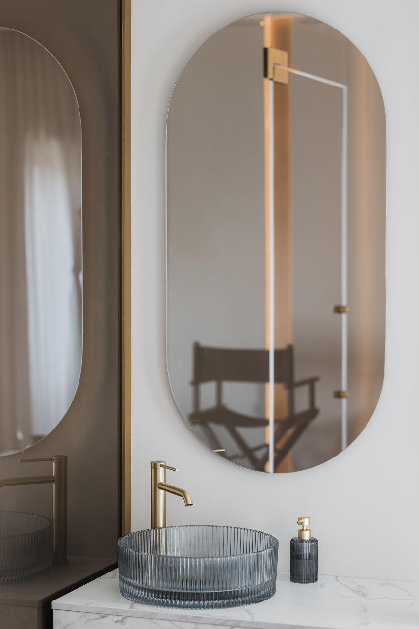 Belle Studio — a bathroom with a fluted-glass basin, satin metal and soft light, where reflections are carefully limited so the space does not feel cold or flat.